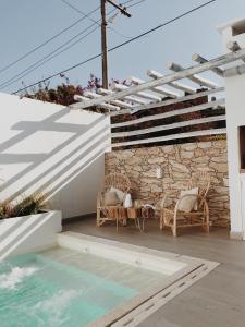 een patio met rieten stoelen en een stenen muur bij Casa Alsina in Chascomús