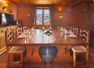 een eetkamer met een grote houten tafel en stoelen bij Les Deux Tetes 2 Chez Fifine in Arc 1600