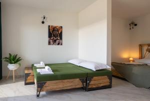沃爾沃羅的住宿－西蒙王子普萊烏公寓式酒店，一间卧室配有一张绿色的床和一张床