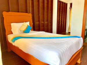 a bedroom with a bed with white sheets and pillows at Nakasang Paradise Hotel in Nakasong