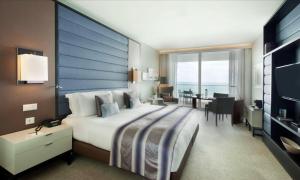 a large bedroom with a large bed and a desk at InterContinental Cascais-Estoril by IHG in Estoril