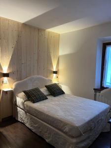 um quarto com uma cama com duas almofadas em Appartamento Belvedere Abetone em Abetone