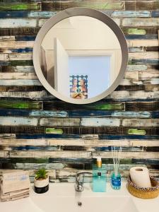 a bathroom with a mirror above a sink at Zambujeira Lounge in Zambujeira do Mar