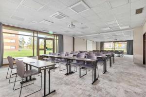 une salle de conférence avec des tables, des chaises et des fenêtres dans l'établissement Best Western Hotel Scheele, à Köping