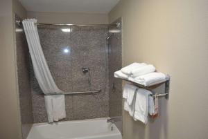 a bathroom with a shower and a toilet and towels at Super 8 by Wyndham Huntersville/Charlotte Area in Huntersville +15 photos