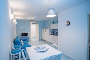 a kitchen with a white table and blue chairs at Casa Azzurra in Cetara