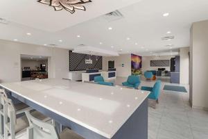 a lobby with a large white counter and blue chairs at Clarion Pointe Kimball in Kimball