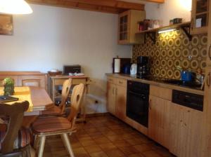 a kitchen with a table and a table and chairs at Ferienhaus-Ilstad in Udler