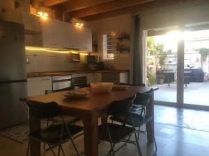 uma cozinha com uma mesa de madeira e algumas cadeiras em Charming house next to the sea and Barcelona for 6 em Badalona