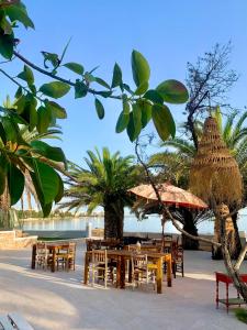 un gruppo di tavoli e sedie su una spiaggia di Hotel Tagomago a Baia di Sant'Antoni