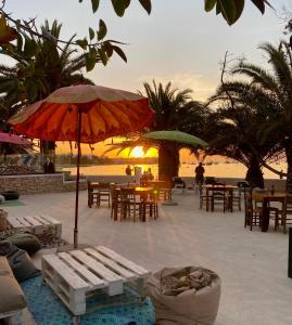 una playa con mesas, sillas y sombrilla en Hotel Tagomago, en Bahía de San Antonio