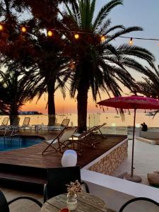 サン・アントニオ・ベイにあるホテル タゴマゴのプールとヤシの木があるリゾートの景色を望めます。