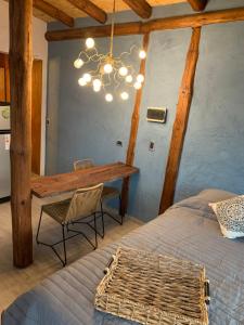 a bedroom with a table and a bed and a chandelier at Revolucionarte.Potrerillos in Potrerillos