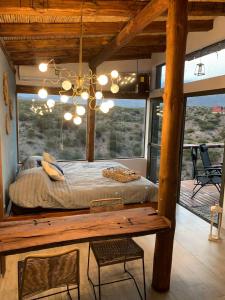 a bedroom with a large bed and a wooden table at Revolucionarte.Potrerillos in Potrerillos