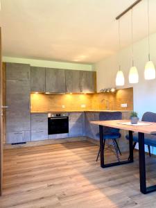a kitchen with a wooden table and a dining room at Apart Theresa in Fügen