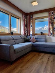 uma sala de estar com um sofá e duas janelas em Apart Theresa em Fügen