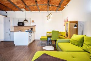 a living room with a green couch and a kitchen at Käserei in Argenbühl