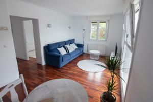 sala de estar con sofá azul y suelo de madera en Atsedenportua, en Arminza