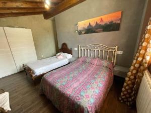 a bedroom with two beds and a painting on the wall at Casa Juan de castilseco 