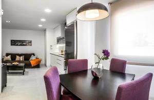 een keuken en eetkamer met een tafel en paarse stoelen bij Apartamentos Levante in Zahara de los Atunes
