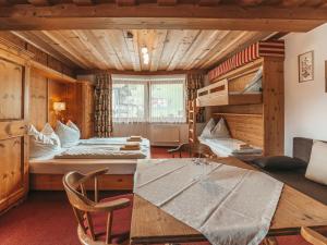 a room with two bunk beds and a table at Hotel Mitterhof in Gerlos