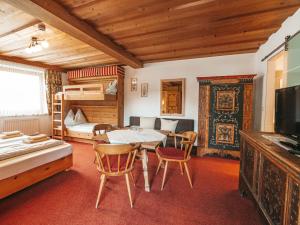 a living room with a table and chairs and a bunk bed at Hotel Mitterhof in Gerlos