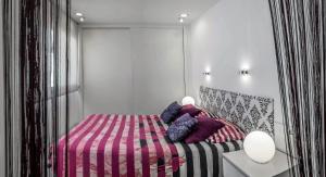 Apartamentos Levante في ساهارا ذي لوس أتونِس: غرفة نوم مع سرير وبطانية وردية وأرجوانية