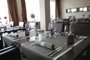 a dining room with a table with glasses and silverware at Hotel Eberhards am Wasser in Bietigheim-Bissingen