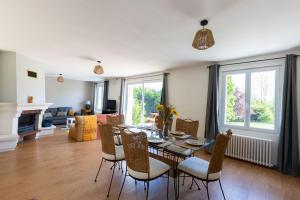 una sala da pranzo e un soggiorno con tavolo e sedie di Maison des Grands Champs a Saint-Aignan