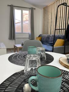 Appartement loft Manosque في مانوسك: طاولة عليها أكواب وصحون