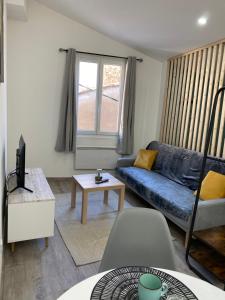 a living room with a blue couch and a table at Appartement loft Manosque in Manosque