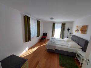 a bedroom with a large bed and a chair at Appartement Lengdorfer in Untertauern