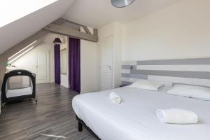- une chambre avec 2 lits blancs et un escalier dans l'établissement Appartement des Grands Champs avec terrasse, à Saint-Aignan