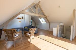 a living room with a table and chairs in the attic at Appartement des Grands Champs avec terrasse in Saint-Aignan