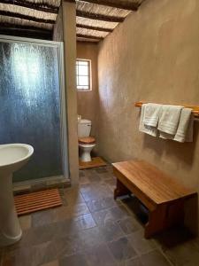 a bathroom with a sink and a toilet and a shower at Oryx Wilderness Game Lodge and Tented Camp 