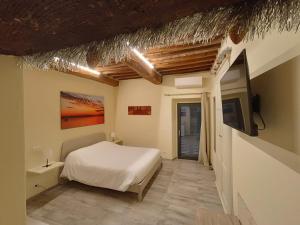 1 dormitorio con 1 cama y TV en la pared en The View - Sunset & Relax - Suite - Appartamenti Vista Lago, en Passignano sul Trasimeno