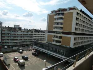 een groot gebouw met een parkeerplaats ervoor bij Appartement Nordmuschel in Westerland in Westerland