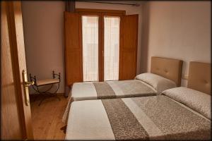 - 2 lits dans une chambre avec fenêtre dans l'établissement Torre Mudéjar, à Teruel