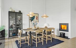 エーベルトフトにあるNice Apartment In Ebeltoft With 2 Bedrooms, Sauna And Wifiのダイニングルーム(テーブル、椅子、暖炉付)