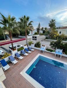 a swimming pool with lounge chairs and a swimming pool at Amsterdam Otel & Suite Apart in Kemer