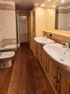 a bathroom with two sinks and two toilets at Appartamento LO SCOIATTOLO in Andalo