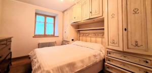 a bedroom with a bed and cabinets and a window at Appartamento LO SCOIATTOLO in Andalo