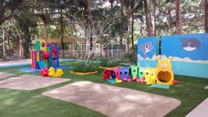 een speeltuin in een park met speelgoed op het gras bij Pico De Loro Condo Unit in Nasugbu