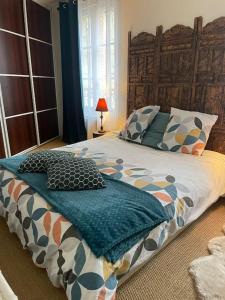 a bedroom with a large bed with pillows on it at Appartement sur le parvis de la cathédrale in Senlis