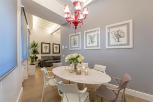 una sala da pranzo con tavolo e sedie bianchi di Diva Lodging Luxury - Signoria a Firenze