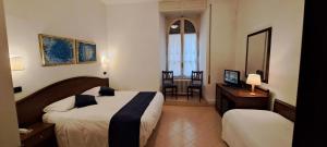 Habitación de hotel con 2 camas, mesa y sillas en Hotel Bonazzi en Perugia