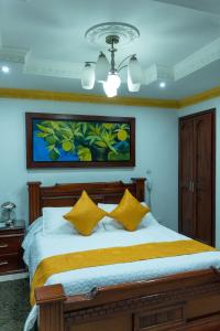 um quarto com uma cama grande e almofadas amarelas em Hotel Aires del Quindío Armenia em Armênia