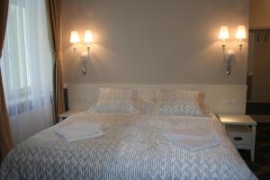 ポラニツァ・ズドルイにあるWilla Mała Pieniawaのベッドルーム1室(ベッド1台、タオル2枚付)