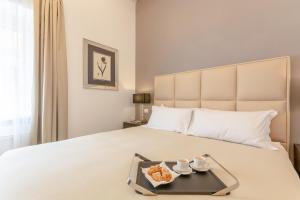 una camera da letto con un letto e un vassoio di cibo sopra di Diva Lodging Luxury - Signoria a Firenze