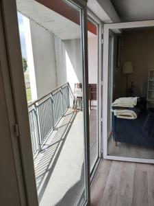een balkon met uitzicht op een kamer met een bed bij Chez justine - Appartement idéalement situé in Mérignac